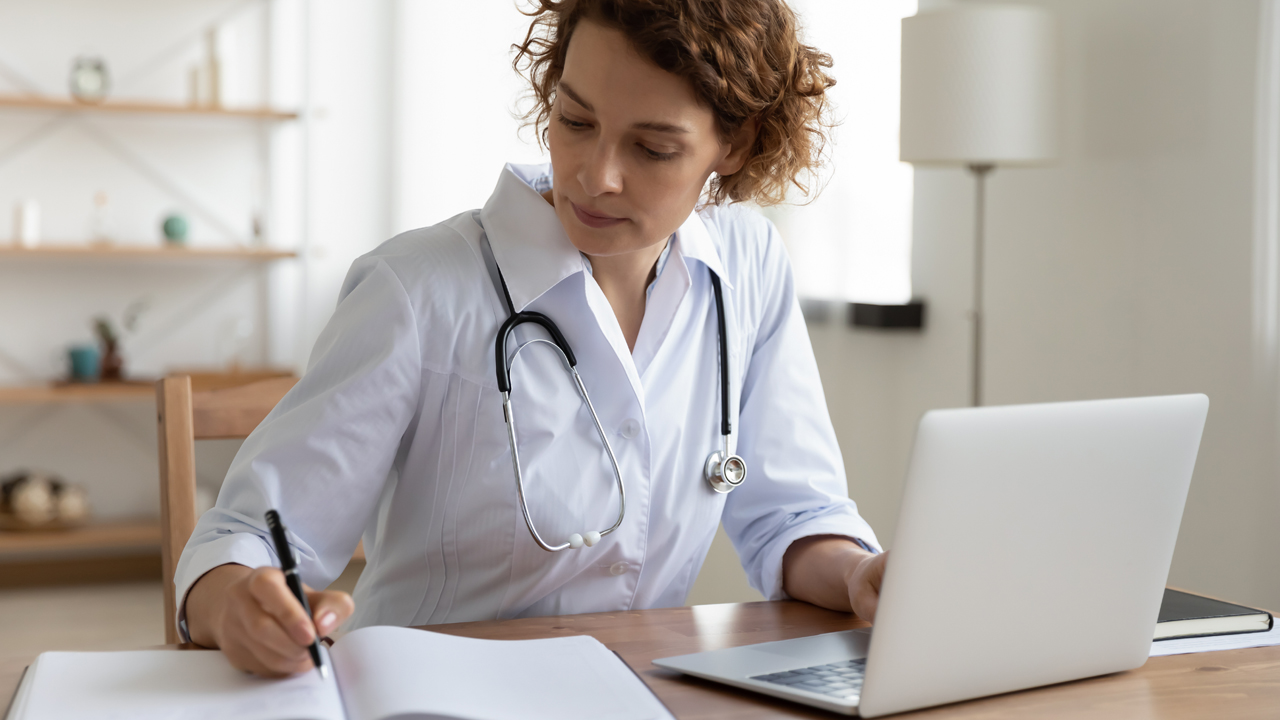 a nurse in whites is making notes on a laptop about the weight loss program